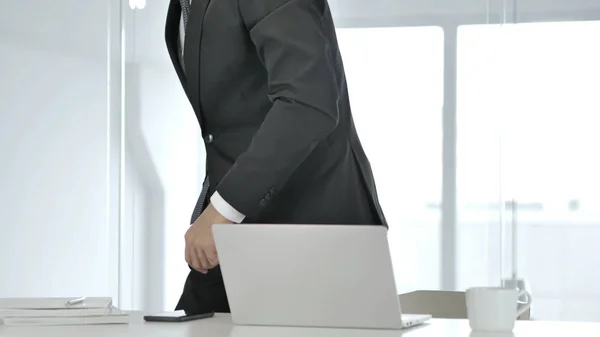 Businessman Leaving Office after Closing Laptop at Work