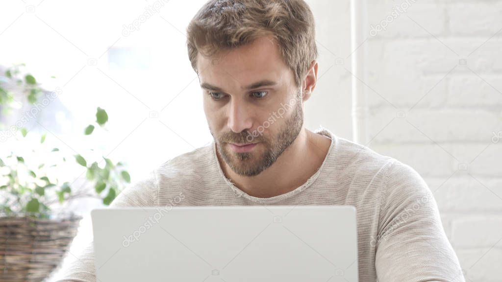 Creative Designer reading On Laptop at Work