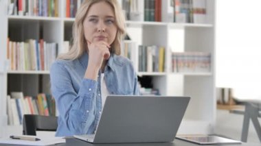 Laptop üzerinde çalışan genç kadın düşünme