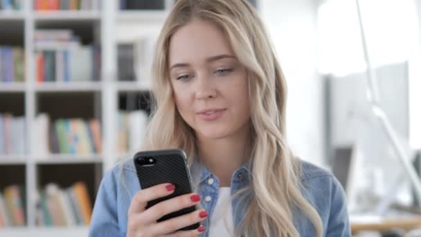 Jonge vrouw enthousiast voor succes op smartphone — Stockvideo