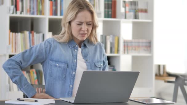 Mulher jovem com dor nas costas espinhal trabalhando no laptop — Vídeo de Stock