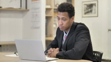 Iş yerinde oturan gülümseyen Afrikalı Işadamı