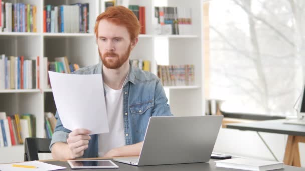 Casual Redhead man Reading kontrakt på jobbet — Stockvideo