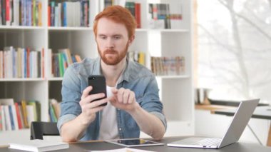 Smartphone üzerinde Internet kullanarak Casual Redhead adam