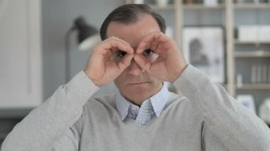 Orta yaşlı adam yeni şans arama tarafından el yapımı binoküler jest
