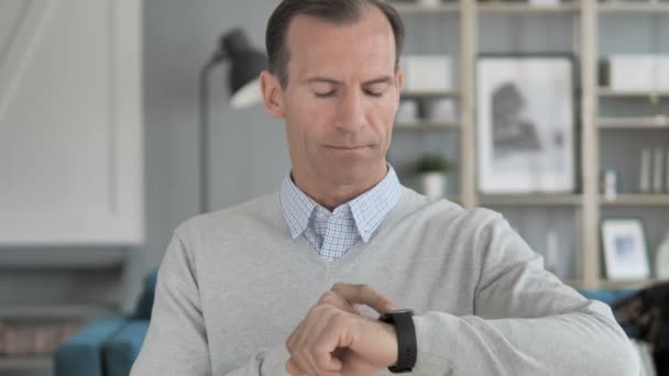 Medelålders man surfar internet på SmartWatch — Stockvideo