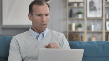 Yaratıcı ofiste laptop çalışırken hasta orta yaşlı adam öksürük