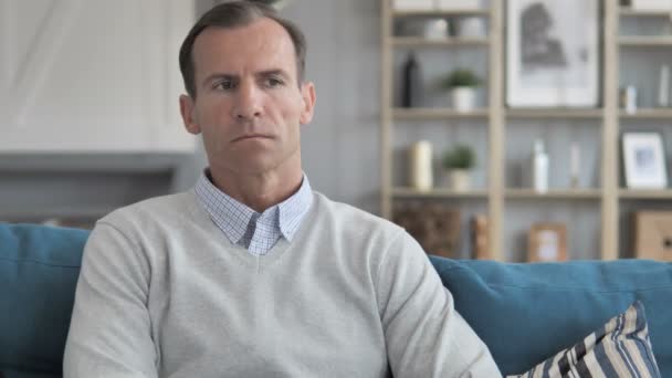 Pensive Moyen Age homme assis sur le canapé dans le bureau créatif — Video