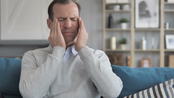 Stressad medelålders man med huvudvärk sitter på soffan — Stockvideo