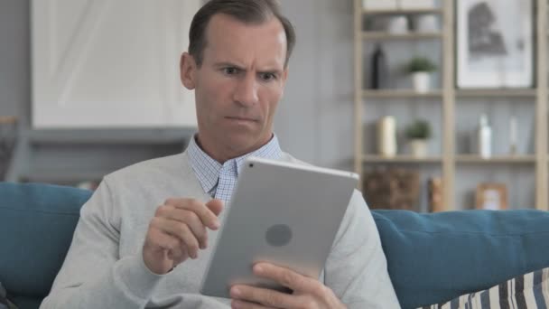 Zvědavý muž středního věku v šoku ze ztráty při používání tabletu — Stock video