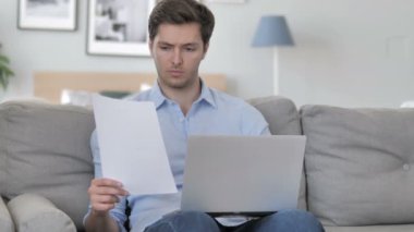 Yaratıcı çalışma alanında otururken yakışıklı genç adam evrak yapıyor