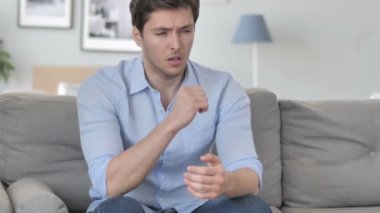 Kanepede otururken hasta genç adam öksürük