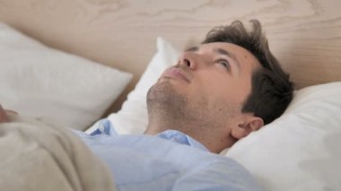 Yatakta yatarken düşünme Pensive genç adam