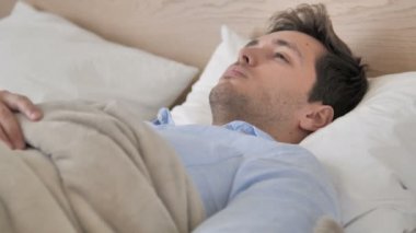 Genç adam uyuyan sonra uyanmak, yatakta bırakarak