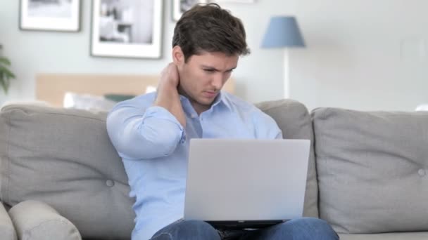 Pohledný mladý muž s bolestí krku bolest pracující na přenosném počítači — Stock video
