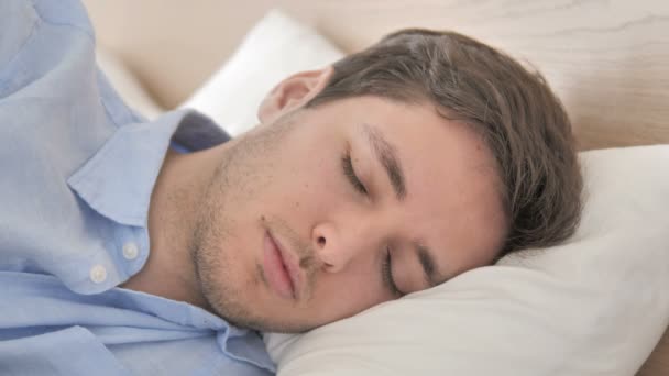 Крупним планом молодий чоловік спить в ліжку — стокове відео