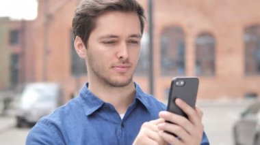 Akıllı telefonda başarı için heyecanlı genç adam açık portresi