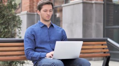 Oturma açık, Genç adam boyun ağrısı laptop üzerinde çalışıyor