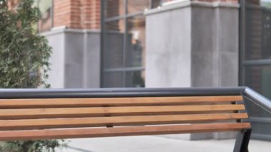 Genç adam geliyor ve laptop kullanmak için Bench oturuyor