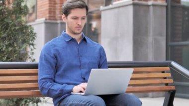 Genç adam laptop kapanış sonra Bench bırakarak