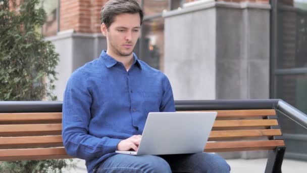 Jonge man verlaten Bank na het sluiten van de laptop — Stockvideo