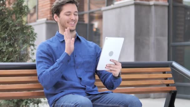 Chat de vídeo en línea en la tableta por el hombre joven — Vídeos de Stock