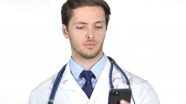 Ung doktor pratar på smartphone, vit bakgrund — Stockvideo