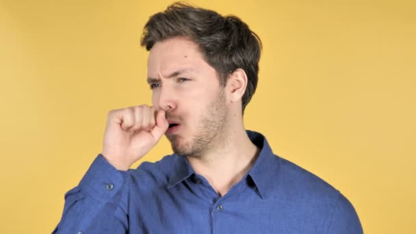 Hombre joven ocasional tosiendo sobre fondo amarillo — Vídeos de Stock