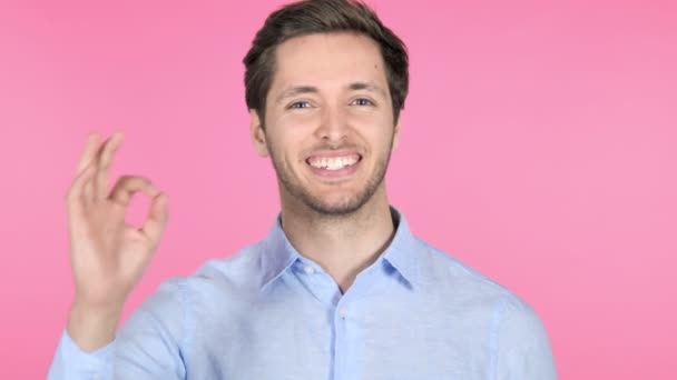 ピンクの背景に若い男によって大丈夫のジェスチャー — ストック動画