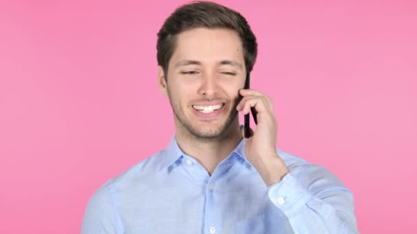 Jovem falando no telefone no fundo rosa — Vídeo de Stock