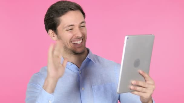 Online Video Chat na tablet przez młodego mężczyznę na różowym tle — Wideo stockowe