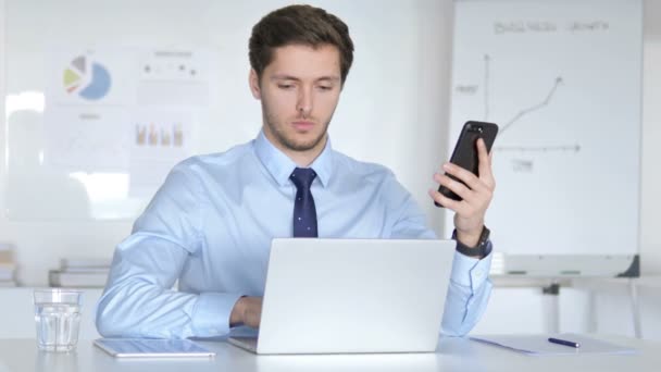 Multitasking affärsman med smartphone, surfplatta och laptop på jobbet — Stockvideo