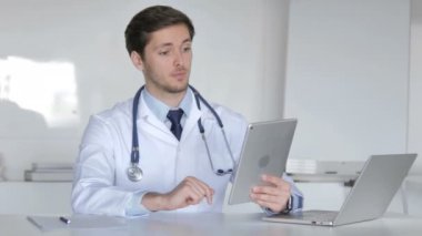 Genç doktor tablette görüntülü sohbet yoluyla hasta ile konuşuyor