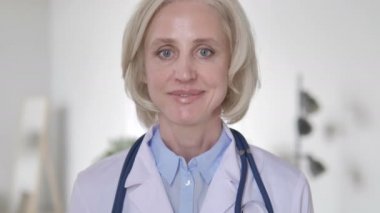 Klinikte gülümseyen kıdemli Bayan Doktor portresi