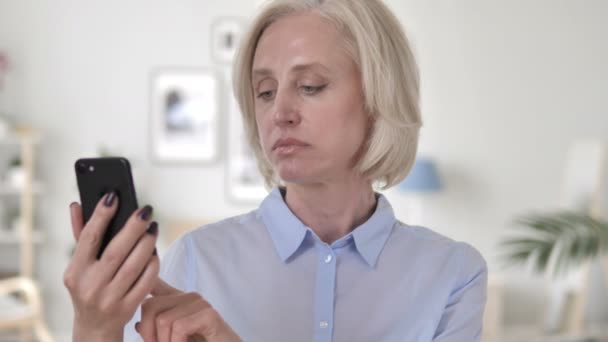 Old Woman Upset by Loss while Using Smartphone — Stock Video