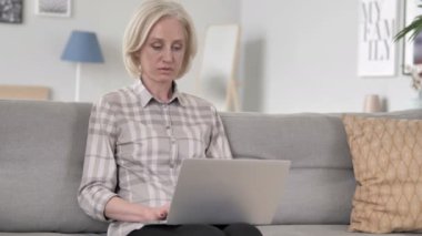 Heyecanlı yaşlı kadın dizüstü başarı kutluyor