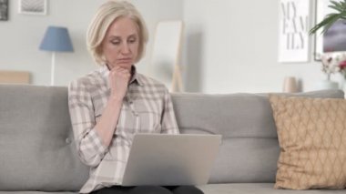 Eski kadın düşünme ve dizüstü bilgisayar üzerinde çalışma