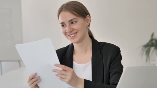 Jeune femme d'affaires lisant des documents au travail — Video