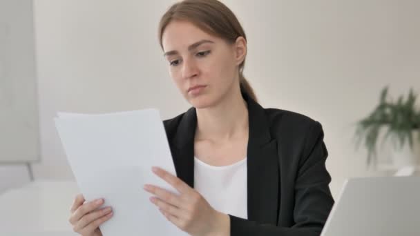 Junge Geschäftsfrau liest Vertrag bei der Arbeit — Stockvideo