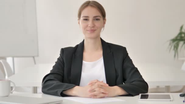 Sonriente joven empresaria en la oficina mirando a la cámara — Vídeo de stock