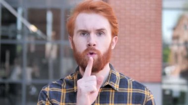 Silence lütfen, parmak üzerinde dudaklar tarafından Redhead sakal genç adam