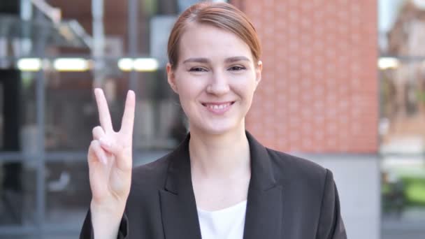 Signe de victoire par jeune femme d'affaires debout en plein air — Video