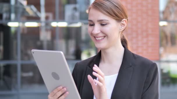 Chat de vídeo al aire libre en la tableta por la joven empresaria — Vídeos de Stock