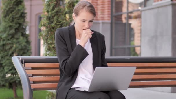 Unga affärskvinna hosta medan du arbetar på laptop utomhus — Stockvideo