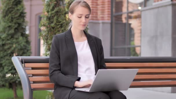 Молода бізнес-леді залишає лавку після закриття ноутбука — стокове відео