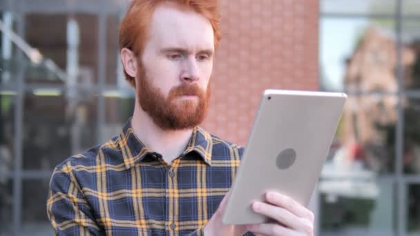 Pelirroja barba joven hombre usando tableta al aire libre — Vídeo de stock