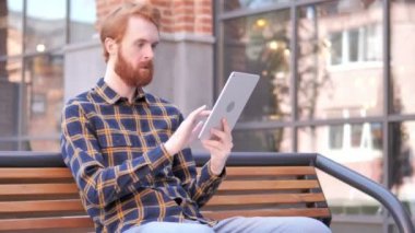 Bench üzerinde oturan süre tablet üzerinde başarı için tezahürat adam