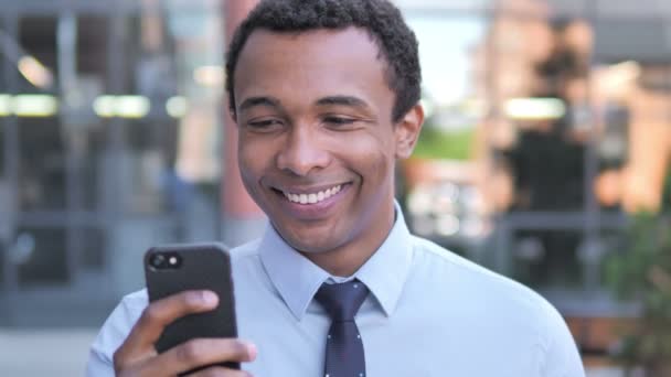 Afrikanischer Geschäftsmann im Freien mit Smartphone — Stockvideo