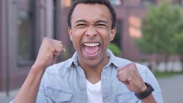 Hombre africano celebrando el éxito al aire libre — Vídeo de stock