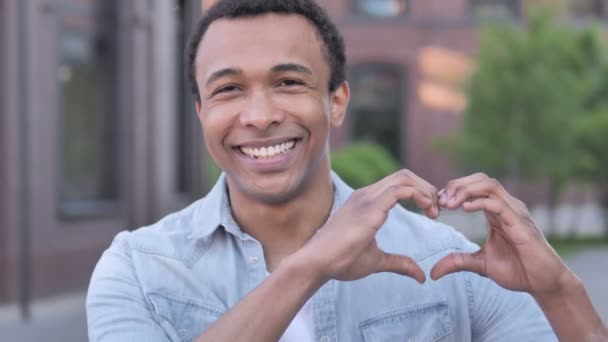Coeur fait main par l'homme africain debout en plein air — Video
